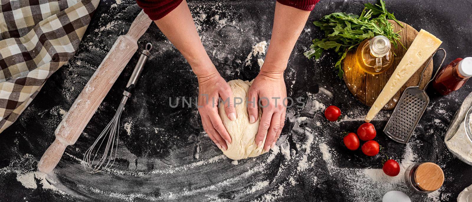 Woman kneading dough for pizza baking by tan4ikk1