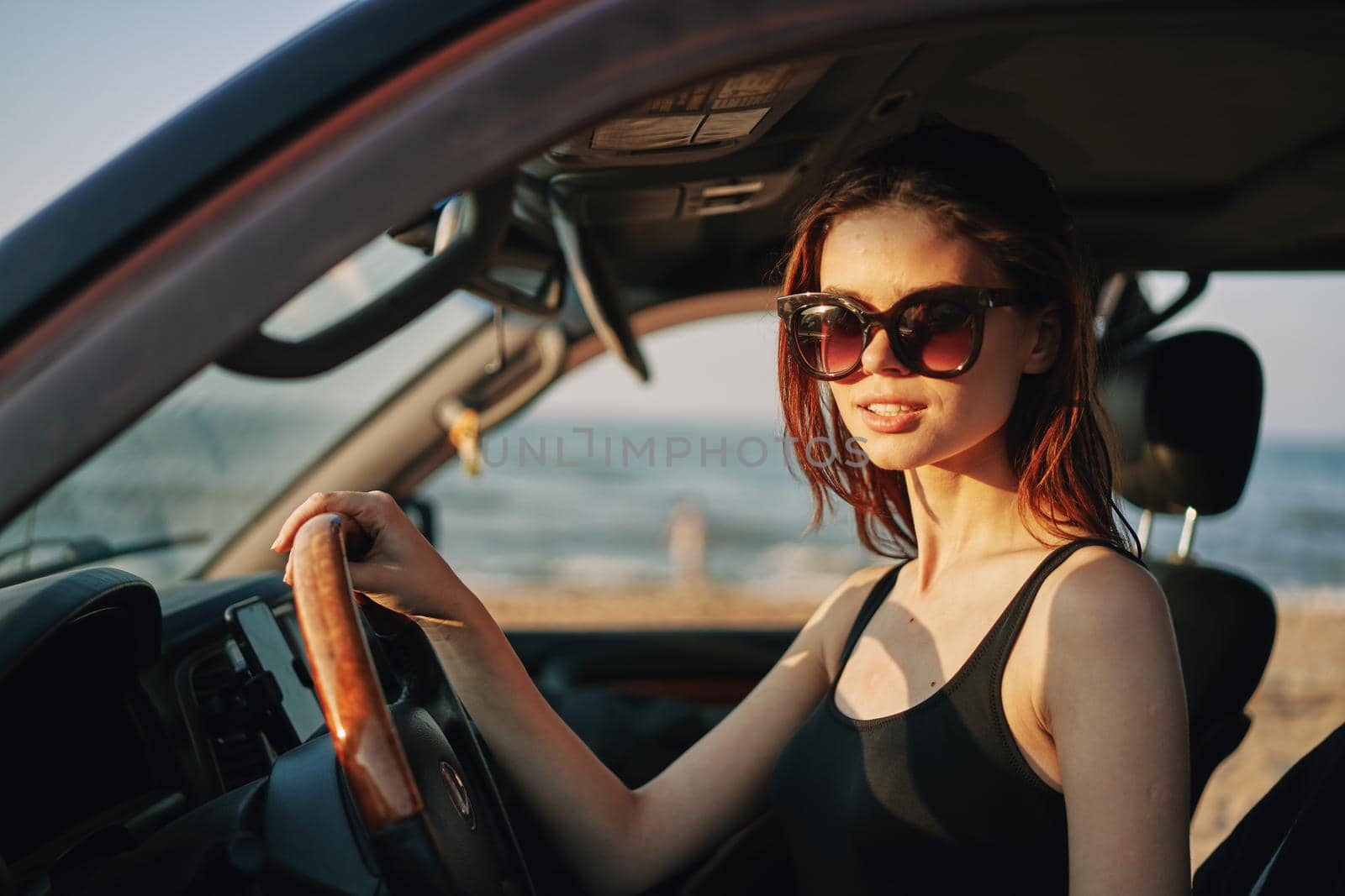 cheerful woman in sunglasses driving a car trip travel. High quality photo