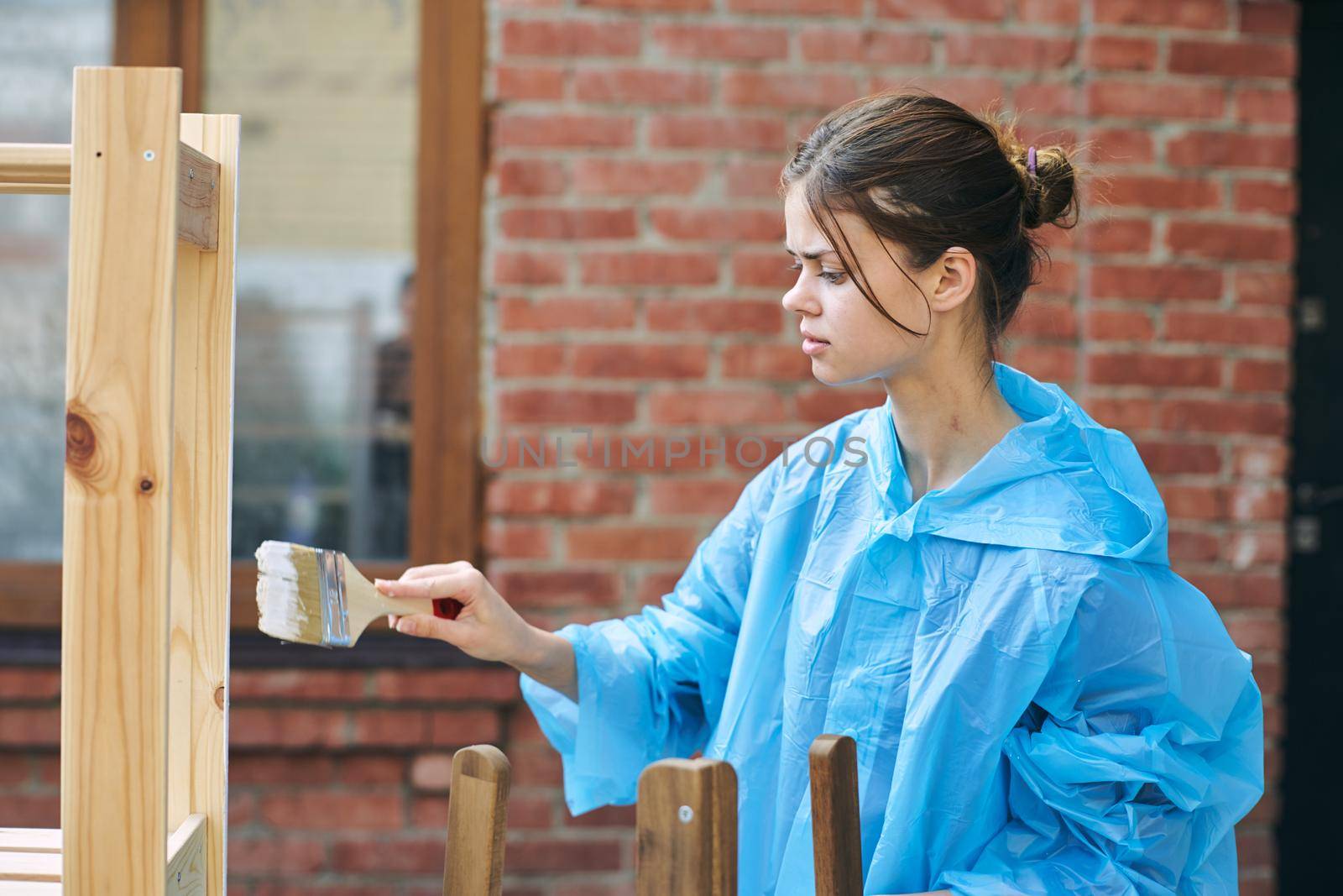 woman house painter renovating wood fittings at home by Vichizh