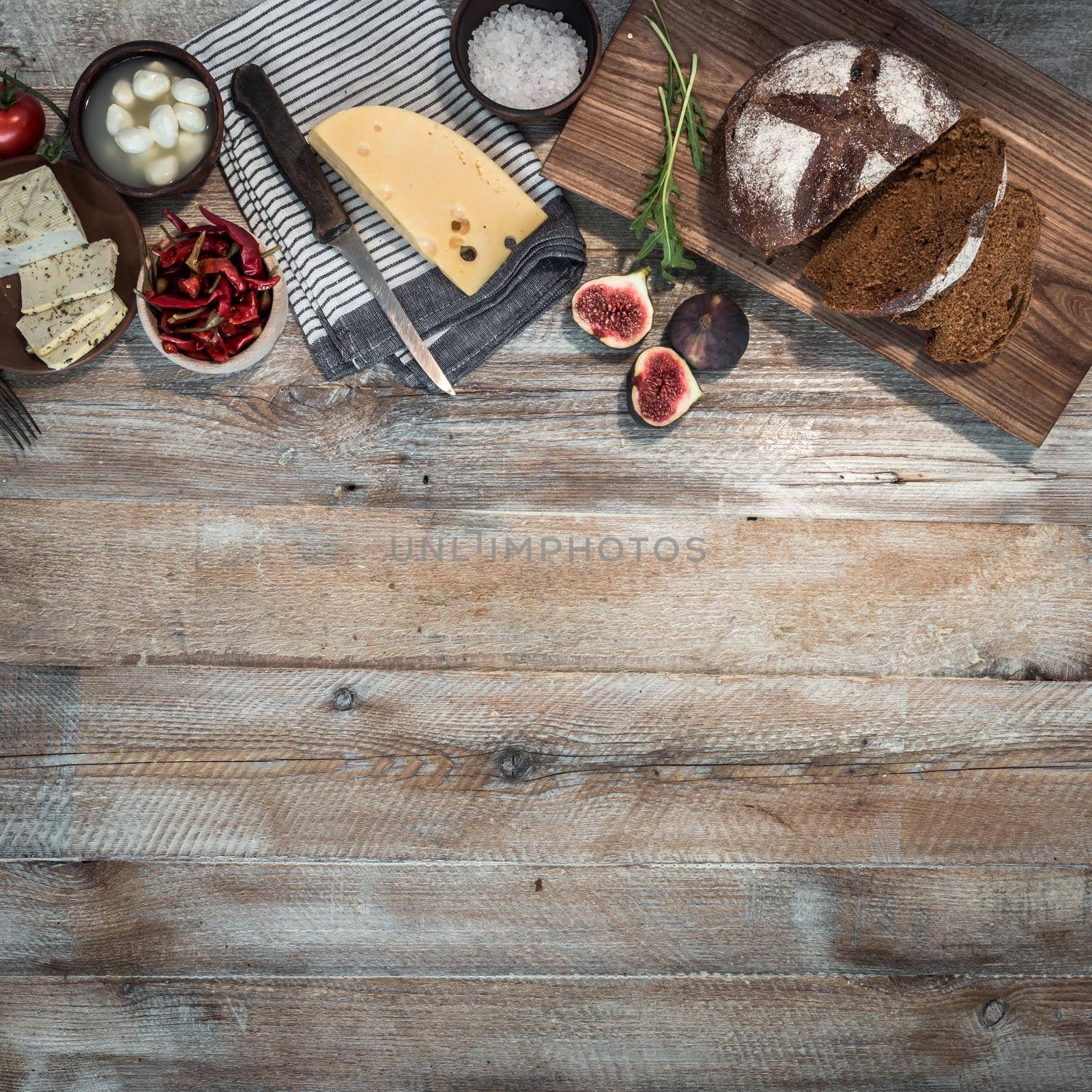 cheeses and brown bread on wooden table with text space