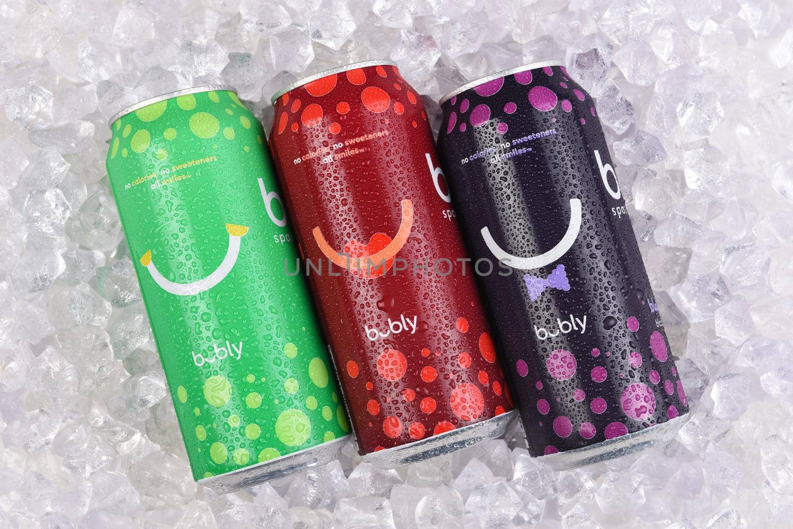 IRVINE, CALIFORNIA - 20 APRIL 2020: Three cans of Bubly Flavored Sparkling Water in a bed of ice, Lime, Cherry and Blackberry flavors.  by sCukrov