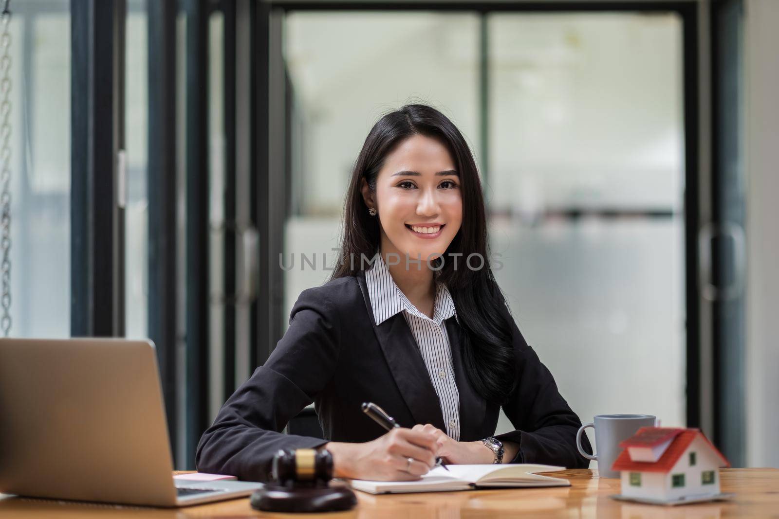 Portrait of business woman and lawyers discussing contract papers with brass scale on wooden desk in office. Law, legal services, advice, Justice and real estate concept.
