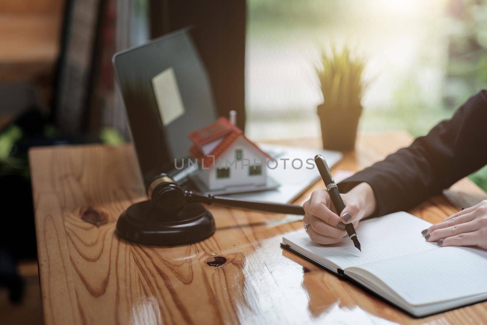 Close up business woman and lawyers discussing contract papers with brass scale on wooden desk in office. Law, legal services, advice, Justice and real estate concept