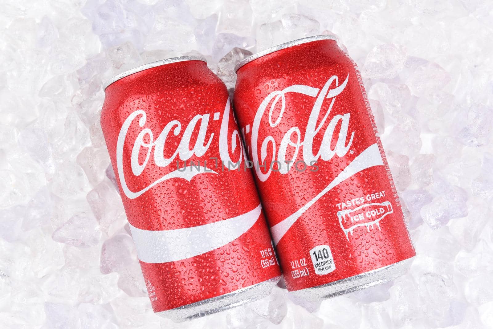 IRVINE, CALIFORNIA - JULY 10, 2017: Two Coca-Cola Cans on a bed of ice with condensation. Coke is the most popular carbonated soft drink in the world.