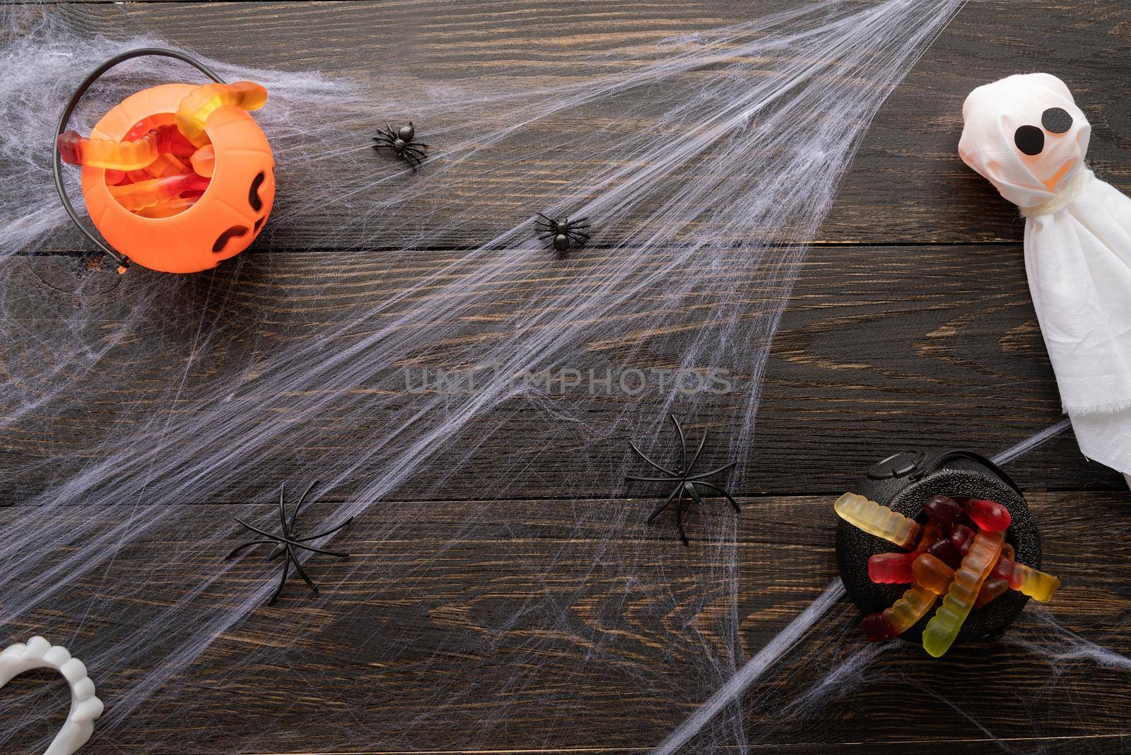 Halloween concept. Halloween holiday background with spider web and spooky decorations on black wooden backdrop