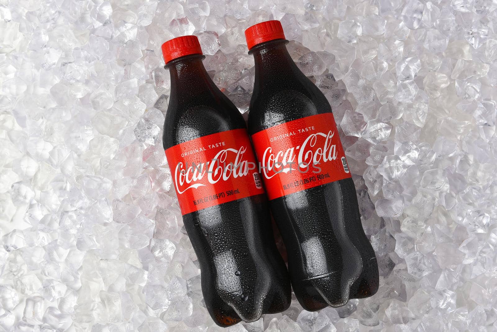 IRVINE, CALIFORNIA - 26 JUNE 2021: Two plastic bottles of Coca-Cola in a bed of ice.