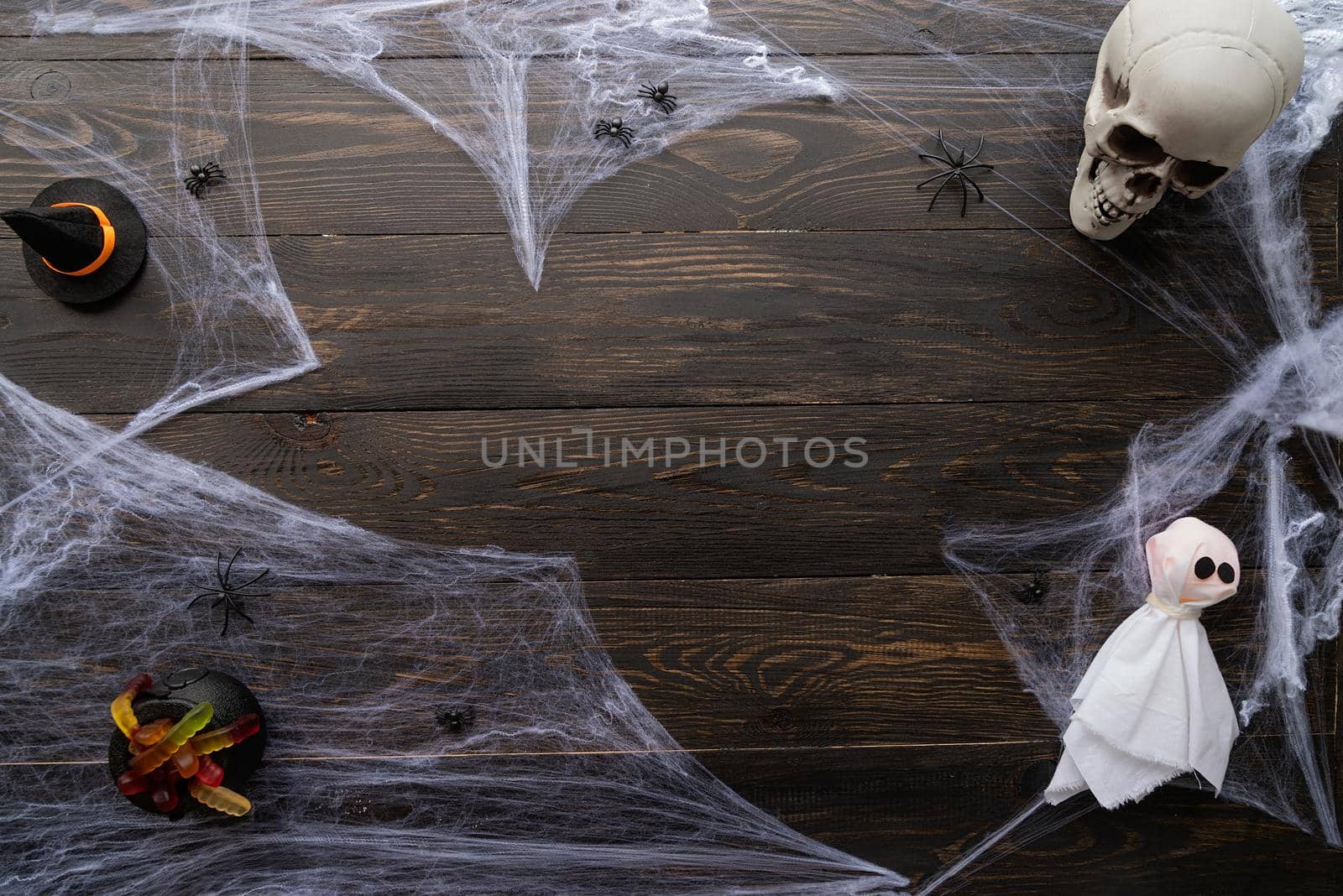 Halloween concept. Halloween holiday background with spider web and spooky decorations on black wooden backdrop. Copy space