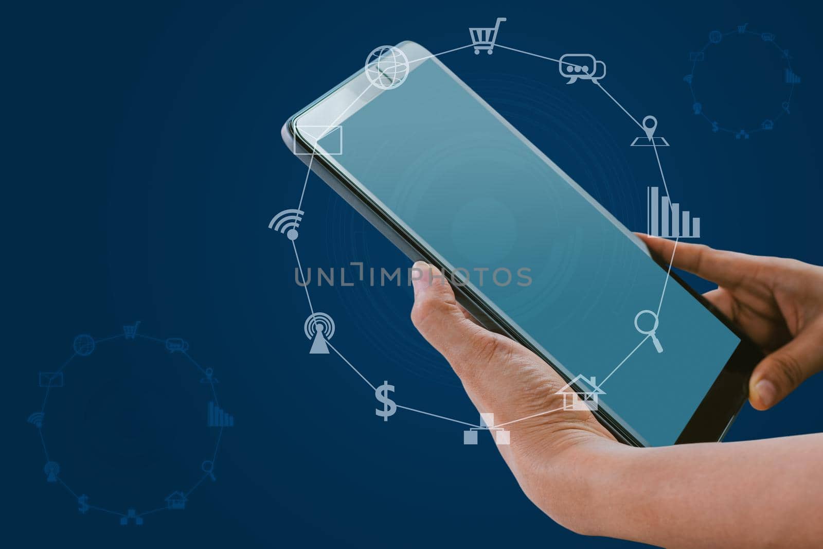 Hand holding tablet with blurred social media and technology icons on blue color background.