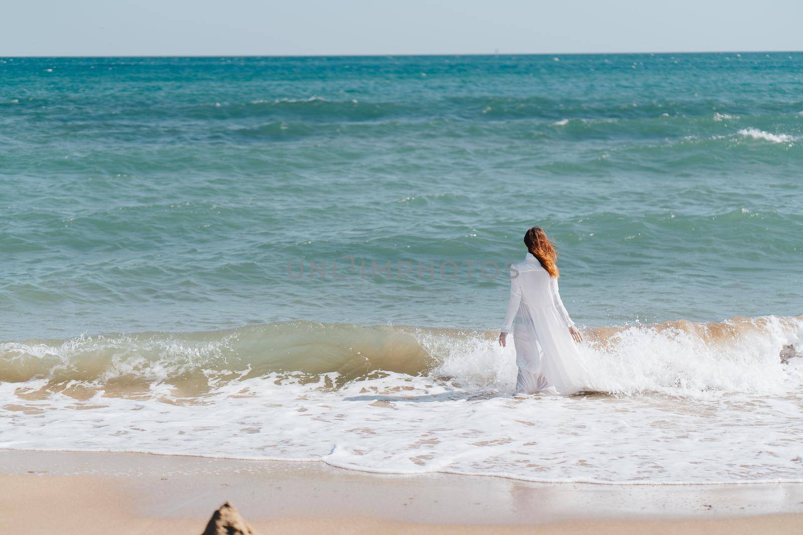 Woman in white dress freedom walk on ocean island. High quality photo