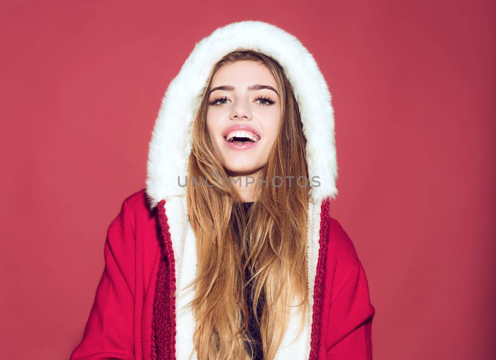 Happy christmas woman in santa claus hat with hood on red background, happy girl at new year party celebration