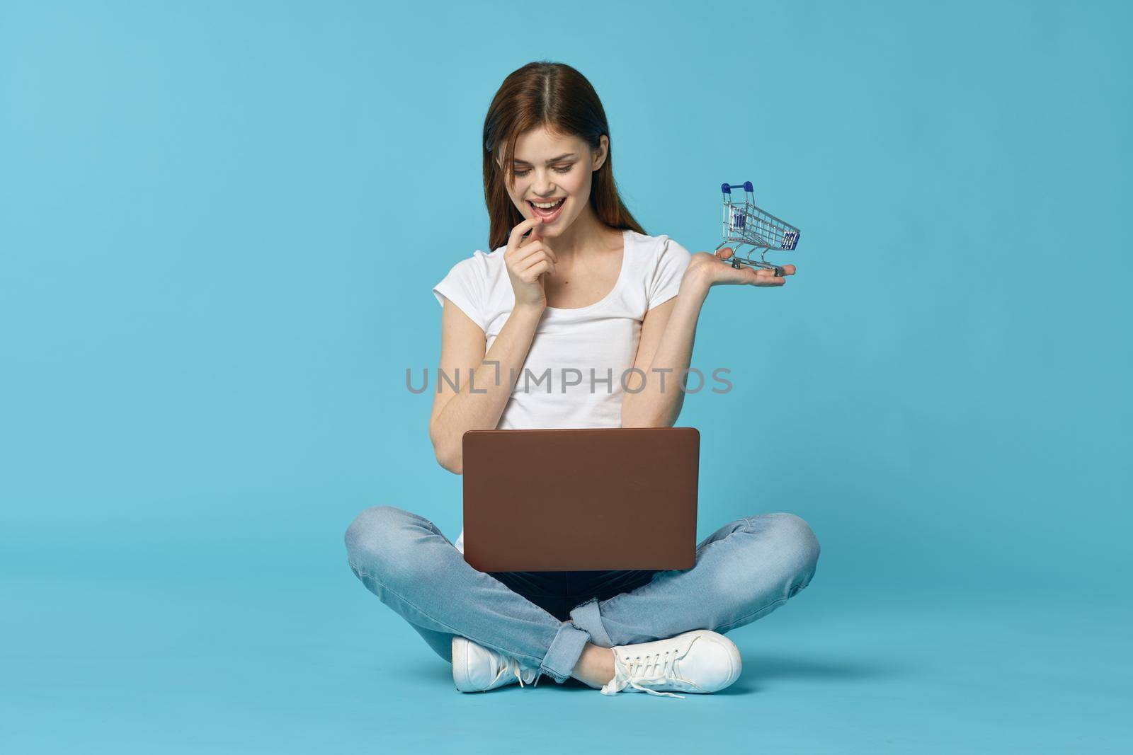 woman with laptop learning internet online education blue background. High quality photo