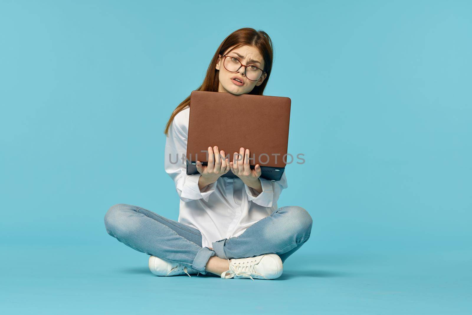 woman with laptop learning internet online education blue background. High quality photo
