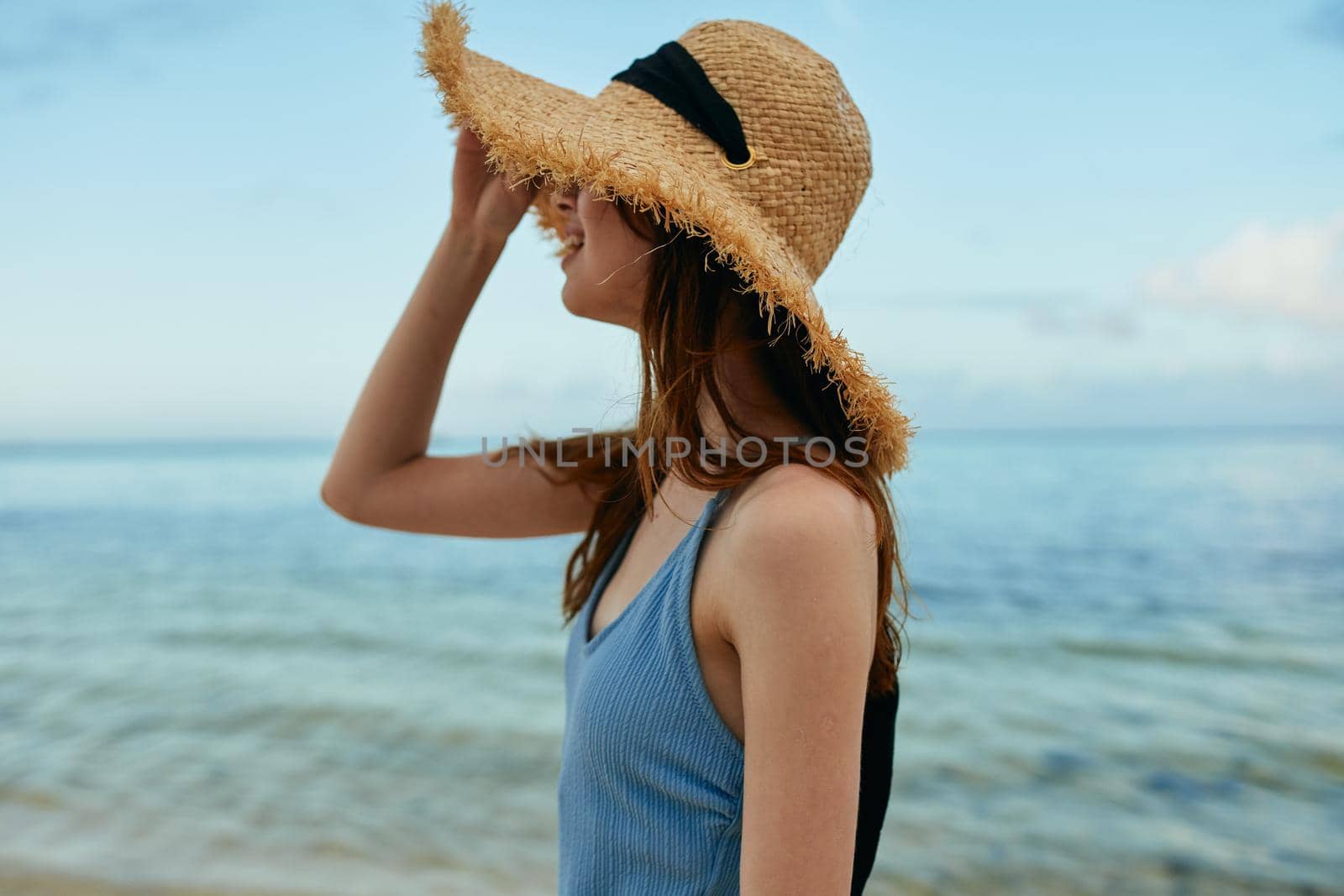 cheerful woman in a beach hat by the ocean island summer. High quality photo