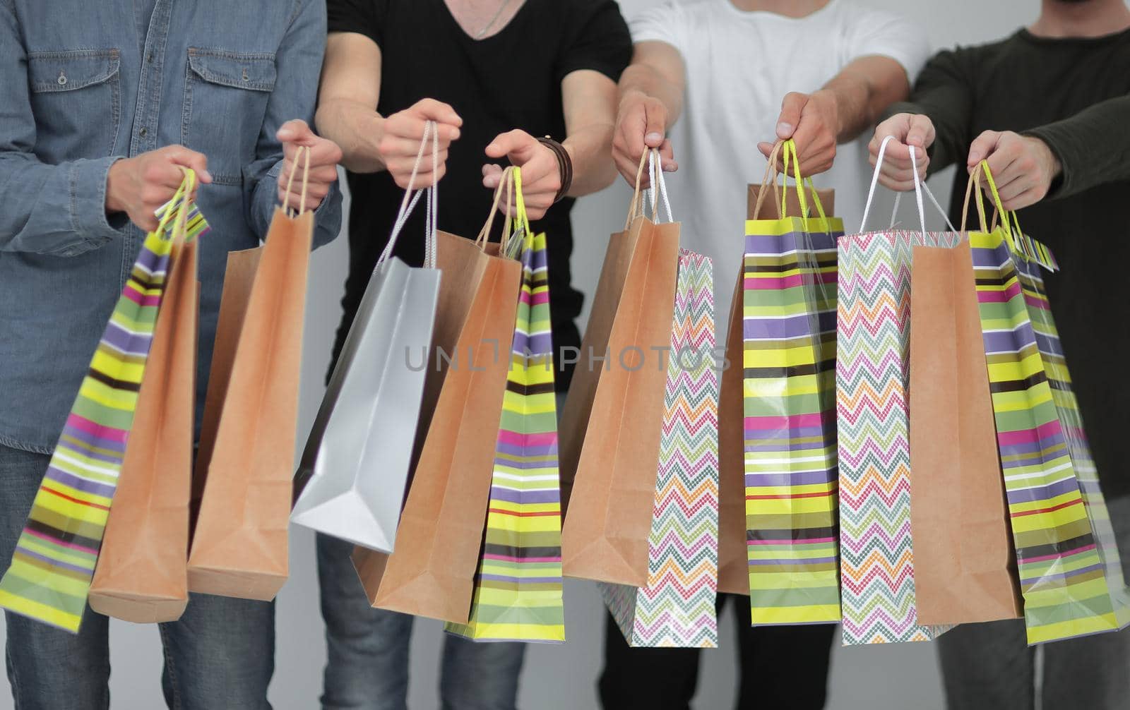 paper bags in the hands of a team of friends.the concept of shopping