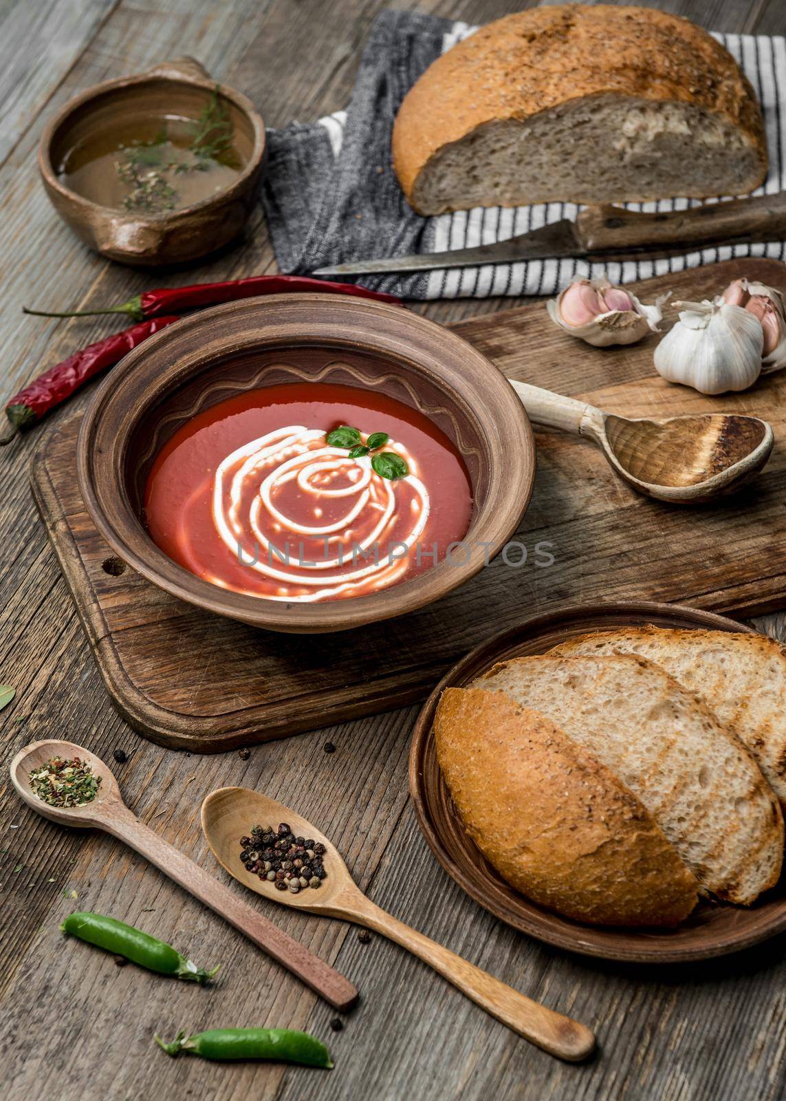 Delicious tomato bisque with homemade bread, rustic dishware and blue squared napkin