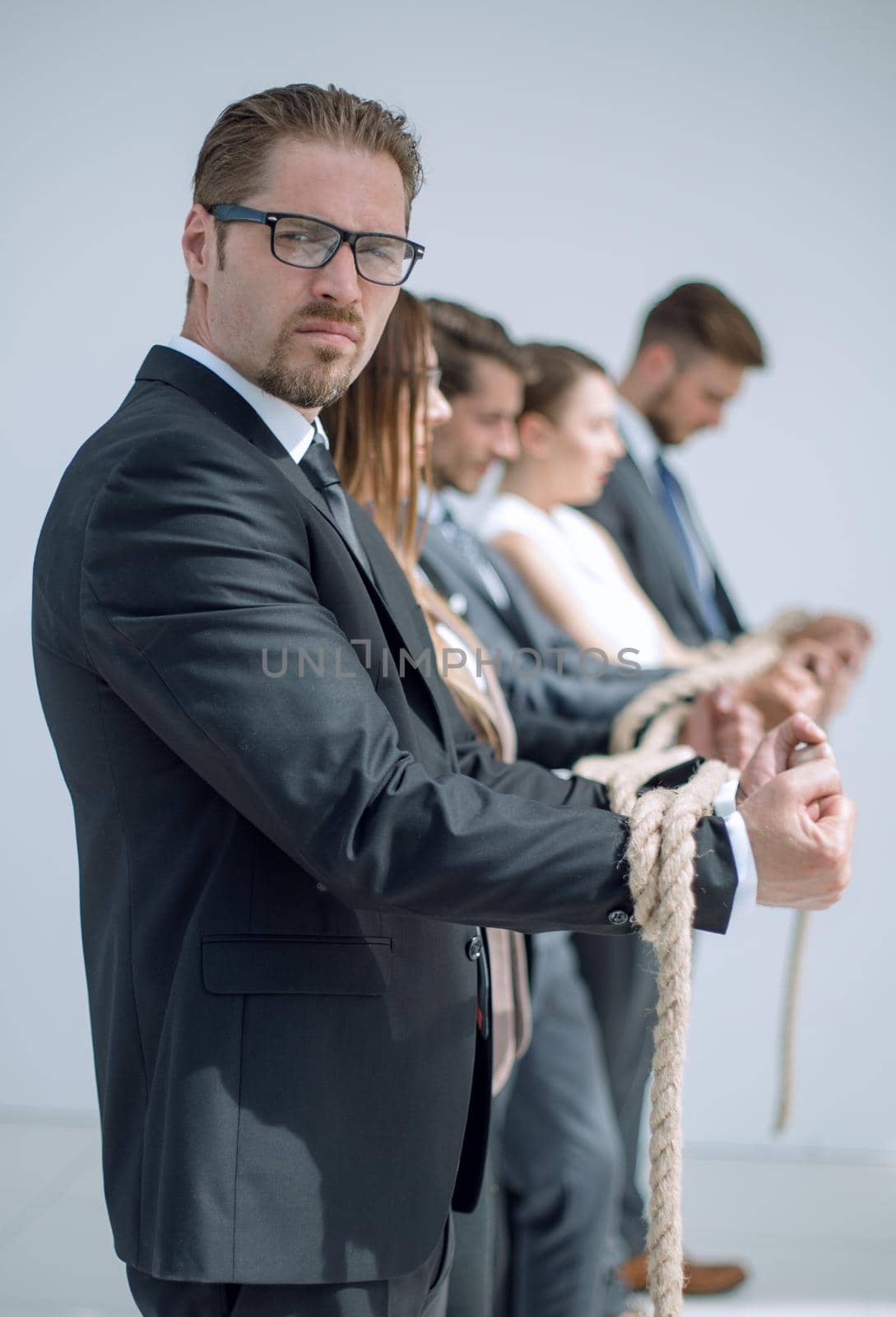 side view.businessman and his team are tied with a strong rope by asdf