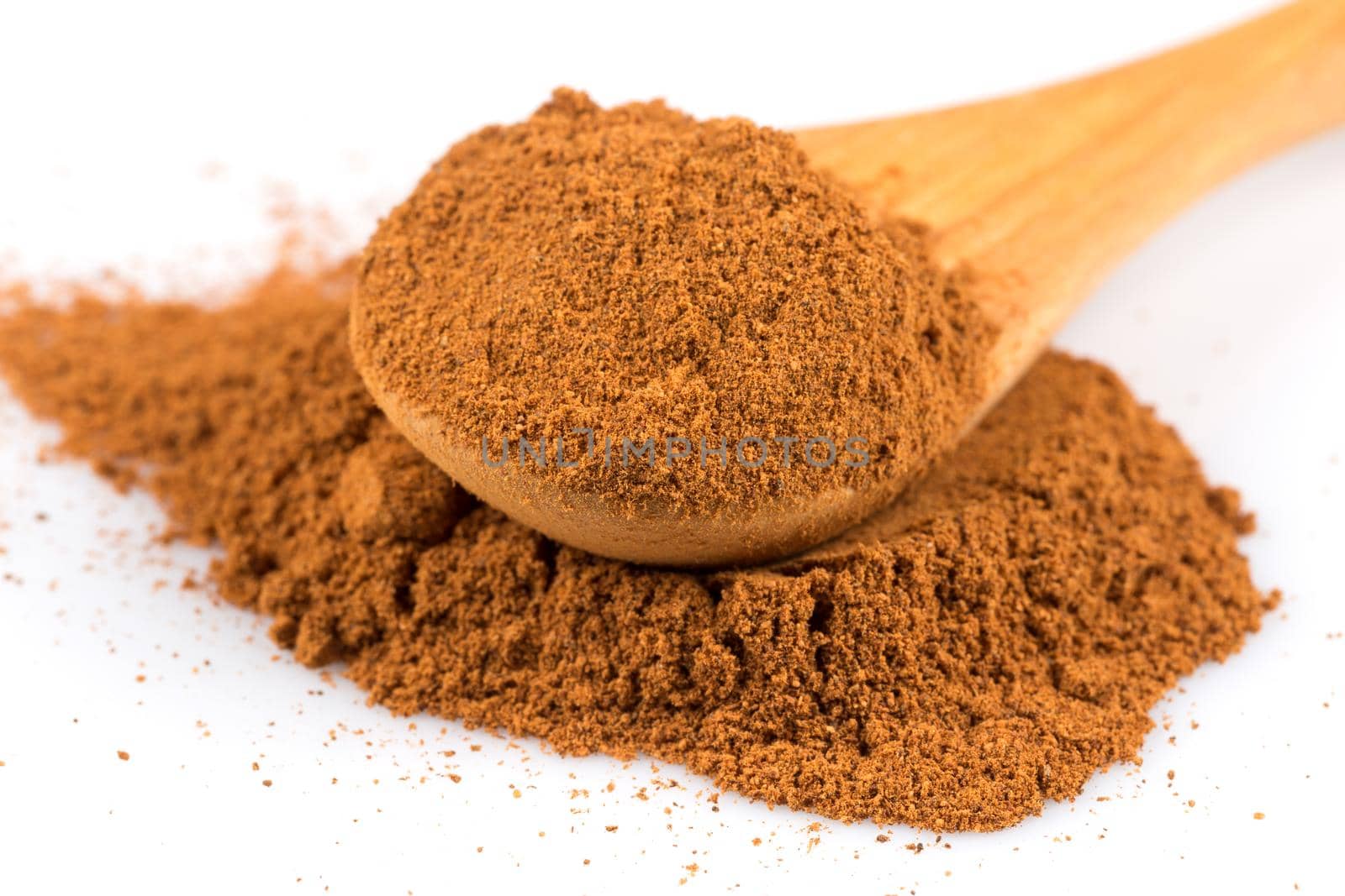 cinnamon ground and spoon isolated on a white background
