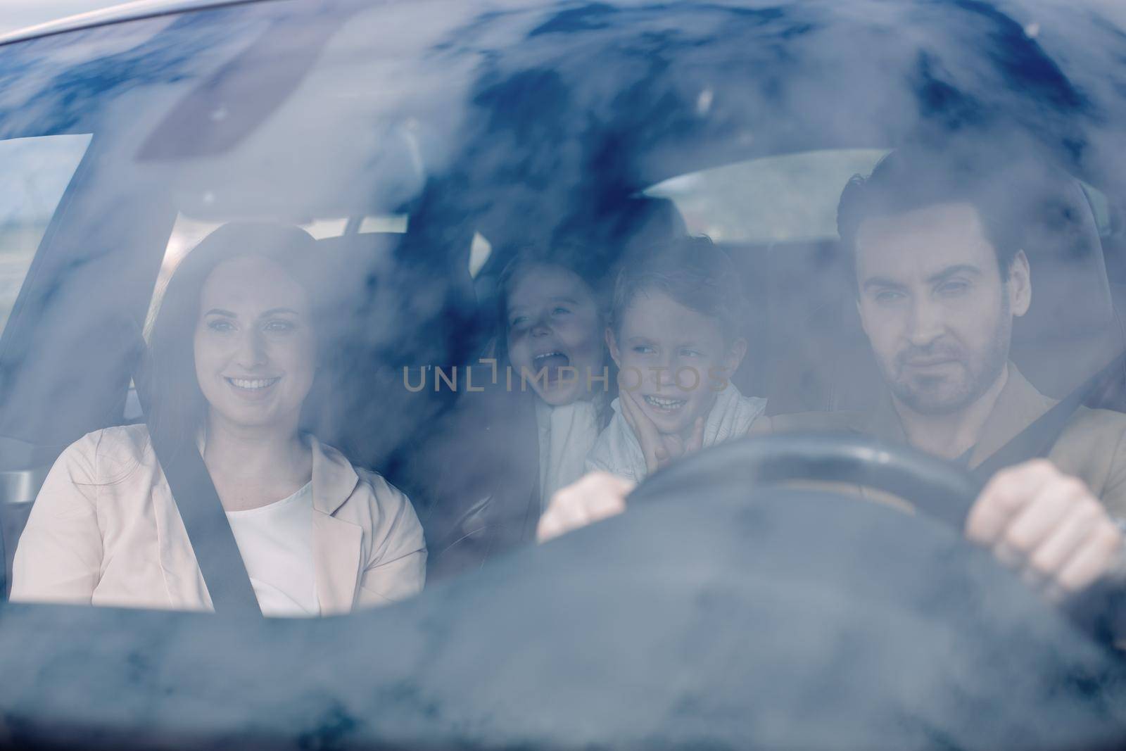 Family sitting in the car looking out windows by asdf