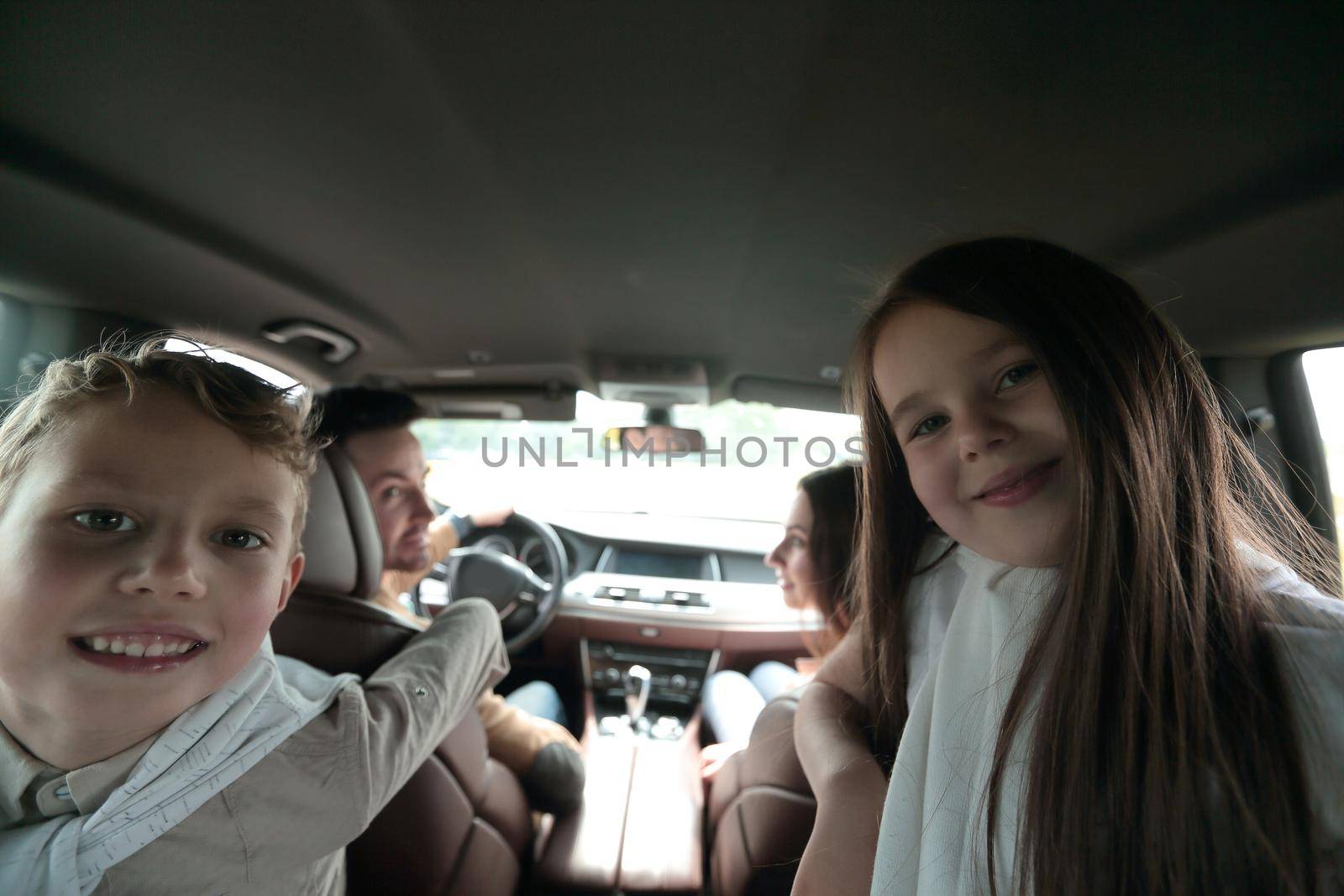 children sitting in the back seat of the car by asdf