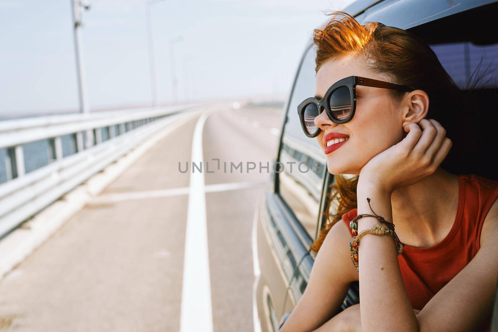 pretty woman in sunglasses rides in a travel car. High quality photo