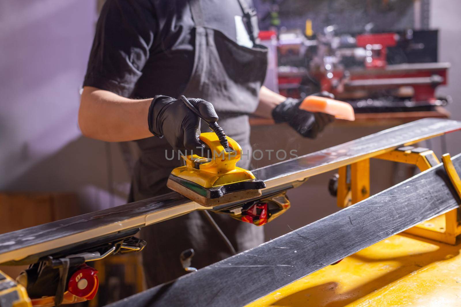 Close up of young man repairing the ski in the service by Satura86
