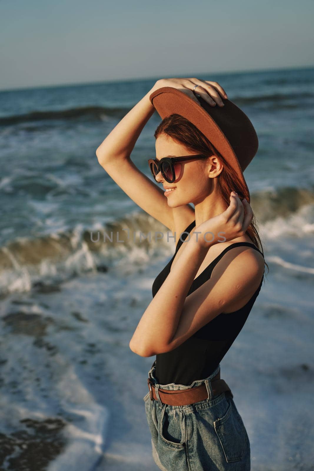 woman walking on the beach hat travel vacation sun. High quality photo