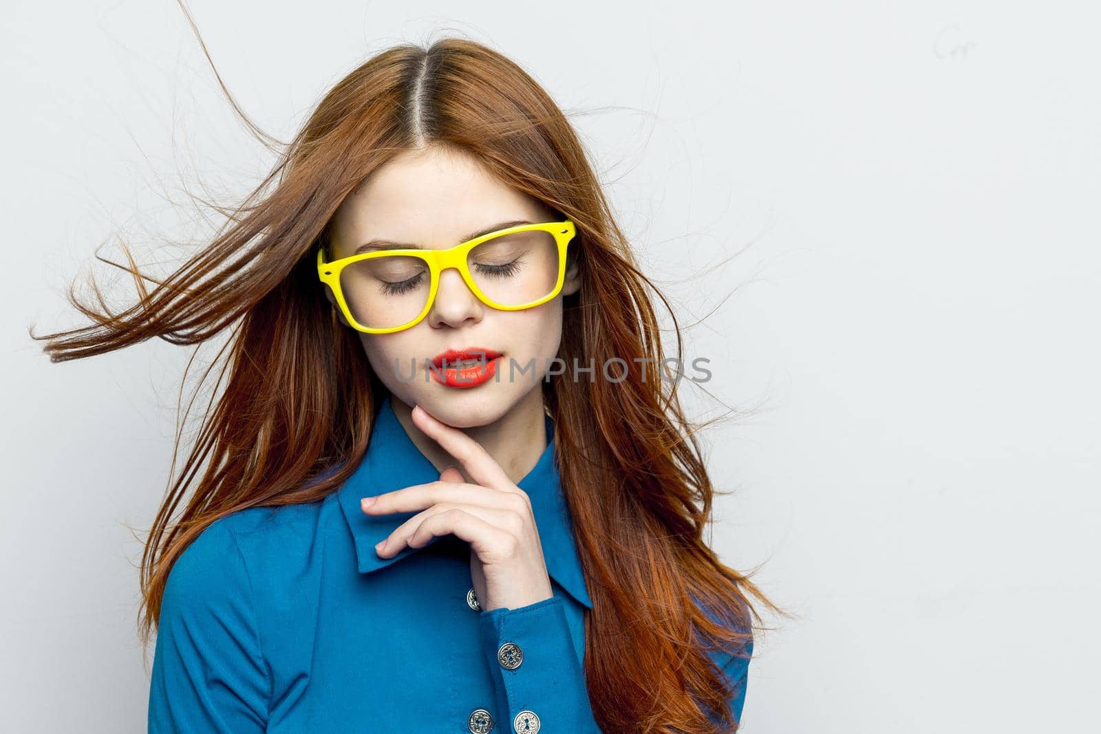 Business woman in blue shirt wearing yellow glasses emotions. High quality photo