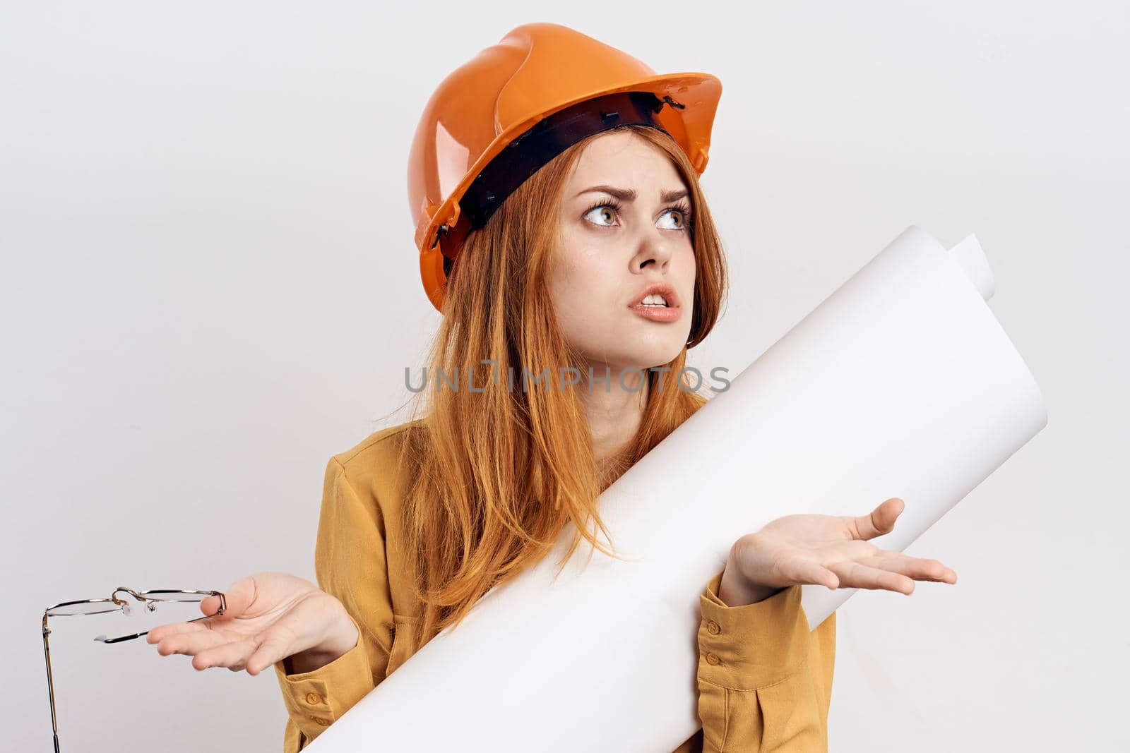 female engineer in orange hard hat blueprints architect. High quality photo