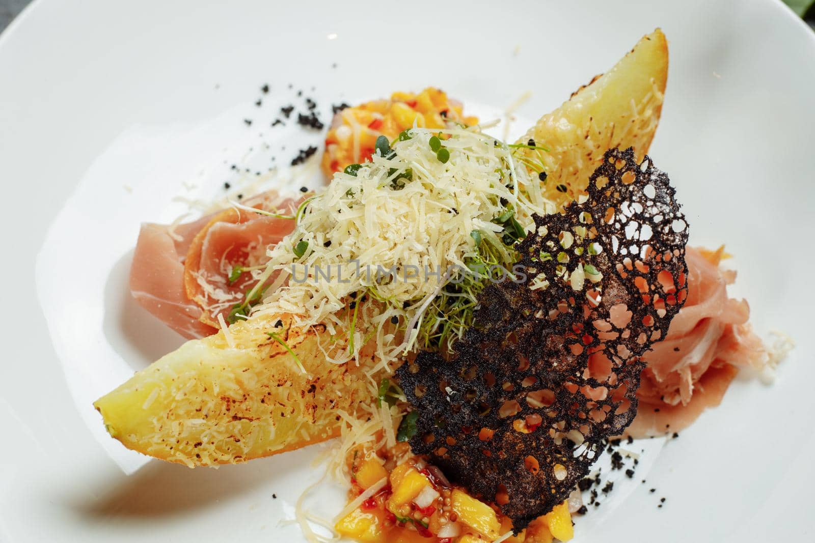 baked melon with parmesan and jamon on a white plate by UcheaD