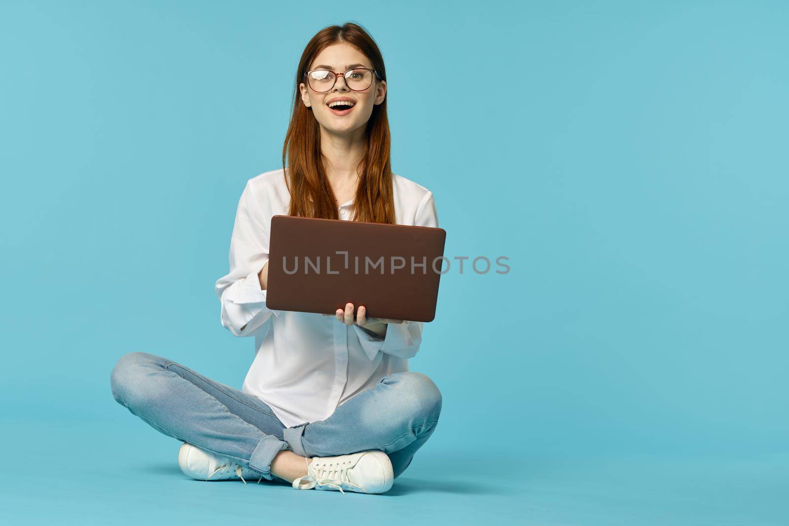 woman with laptop learning internet online education blue background. High quality photo