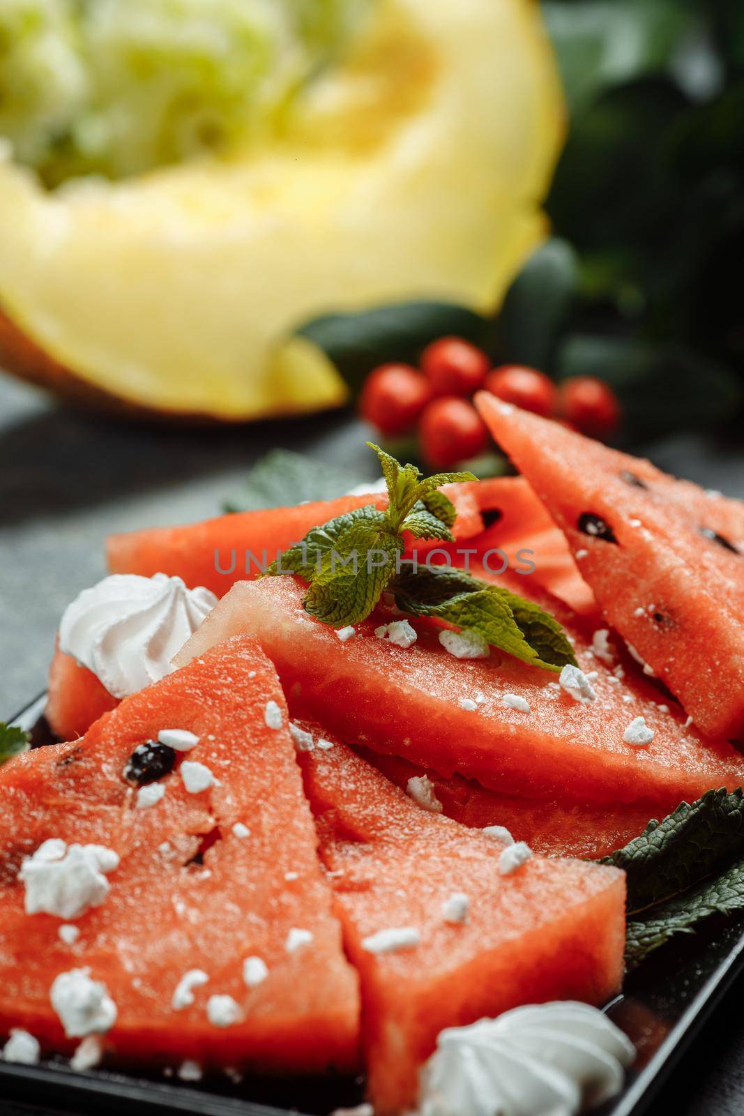 Pieces of fresh red watermelon on a black plate.