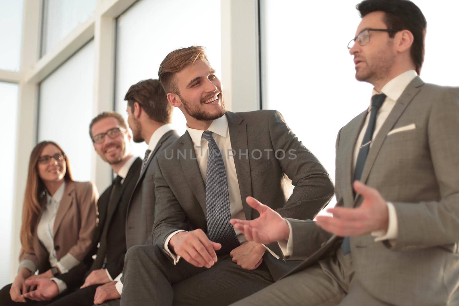 Cheerful businessmen meeting with colleagues in a bright office