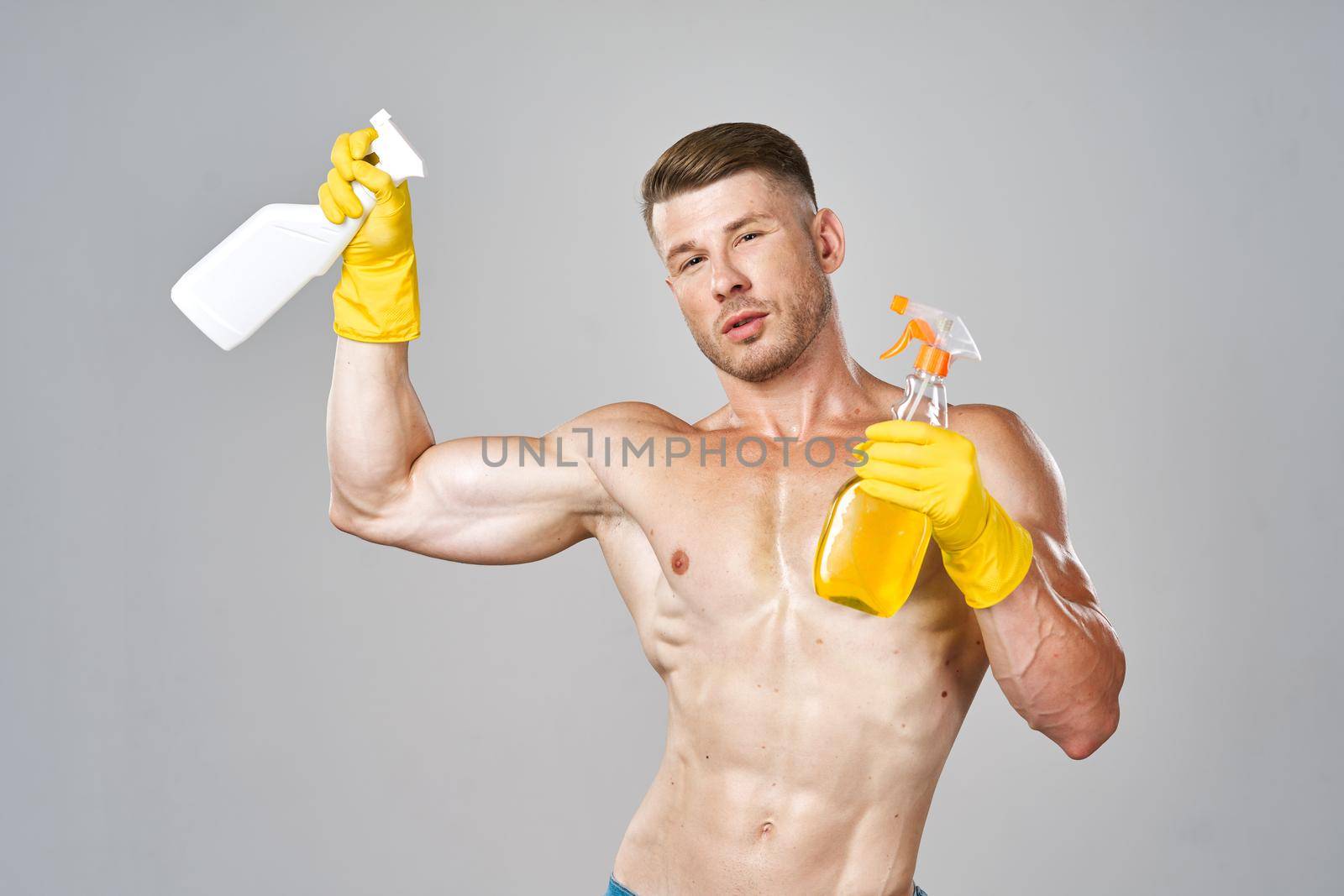man with pumped up muscular body detergent rubber service gloves. High quality photo