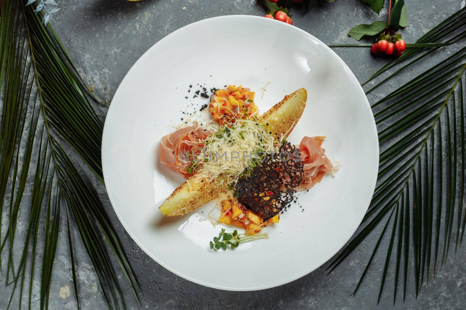 baked melon with parmesan and jamon on a white plate.