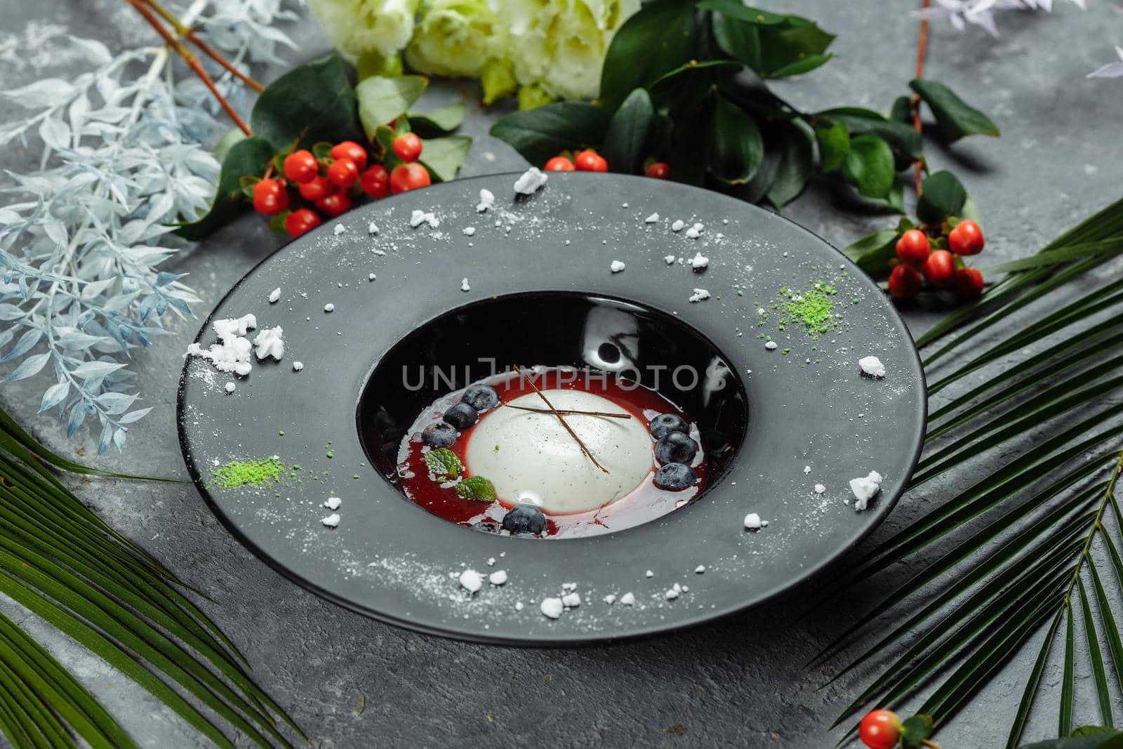 Panna cotta with raspberry sauce in a black plate by UcheaD