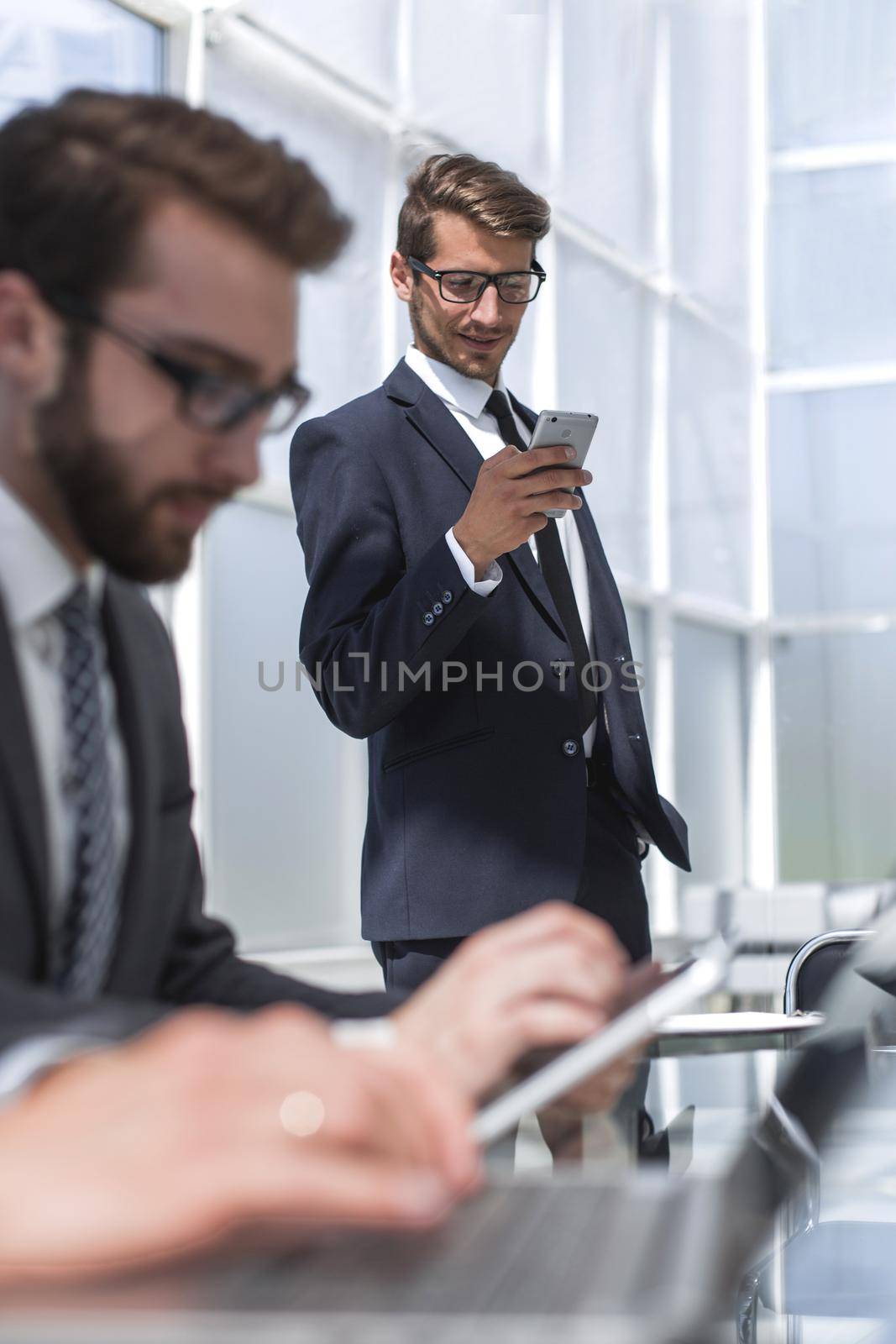 close up.business team using gadgets in a modern office by asdf