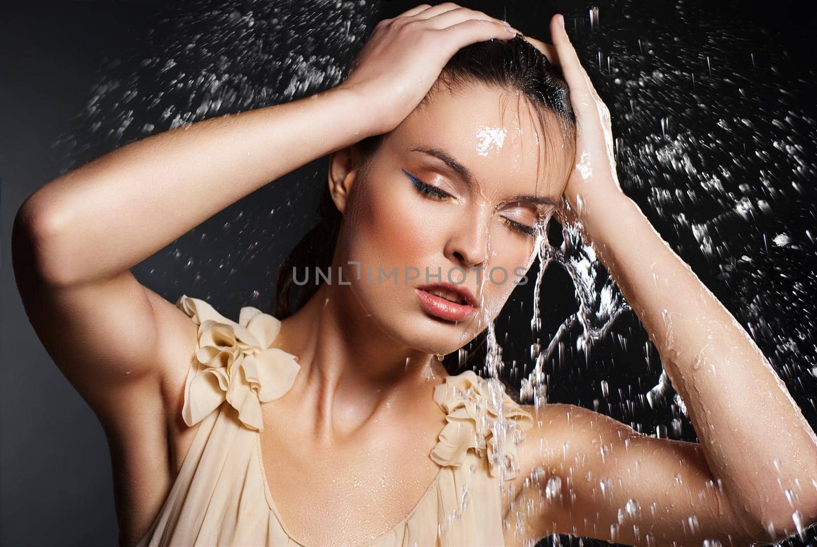 Portrait of young sensuality beautiful woman under the stream of water - blue background