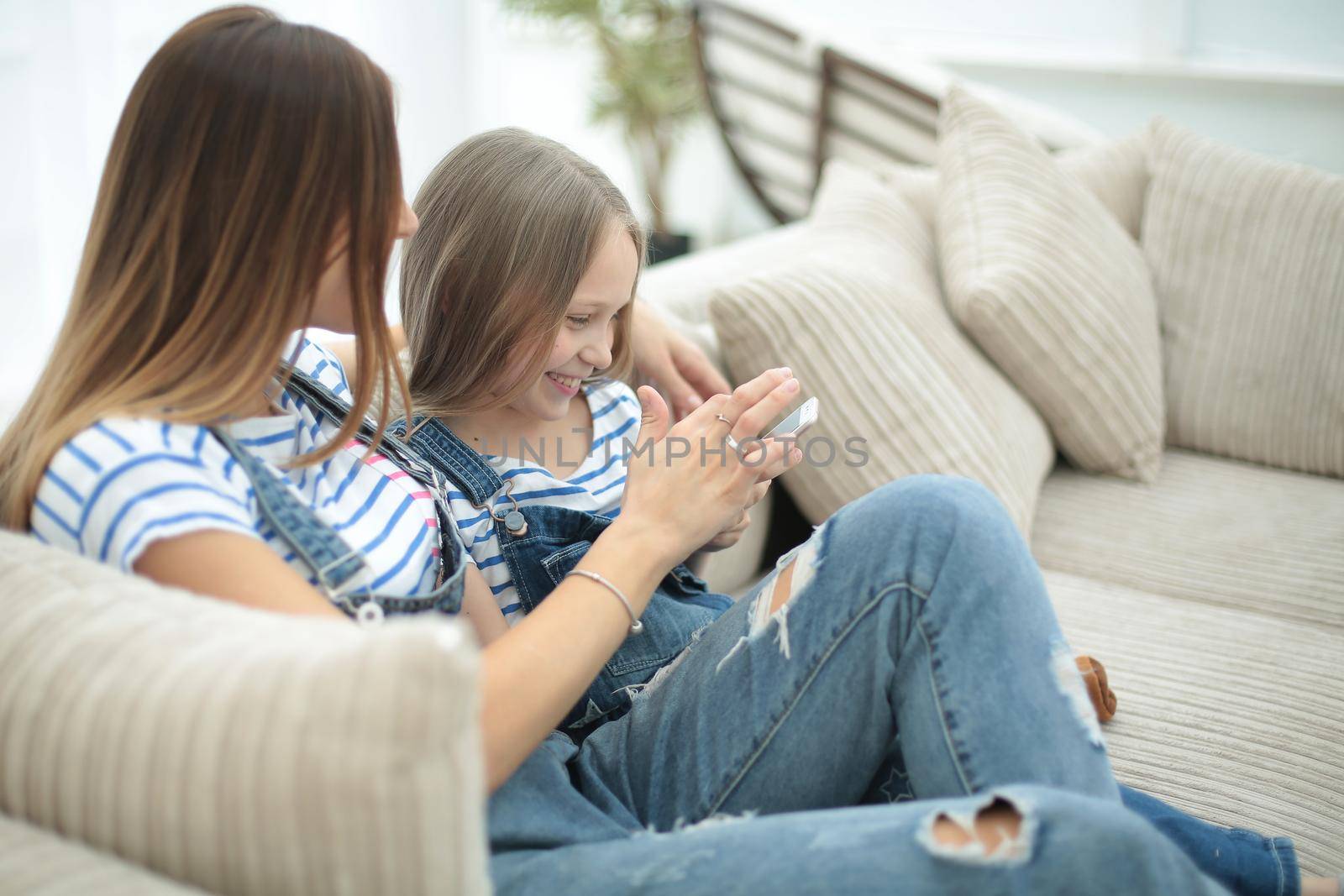 mom and her daughter reading SMS on smartphone by asdf