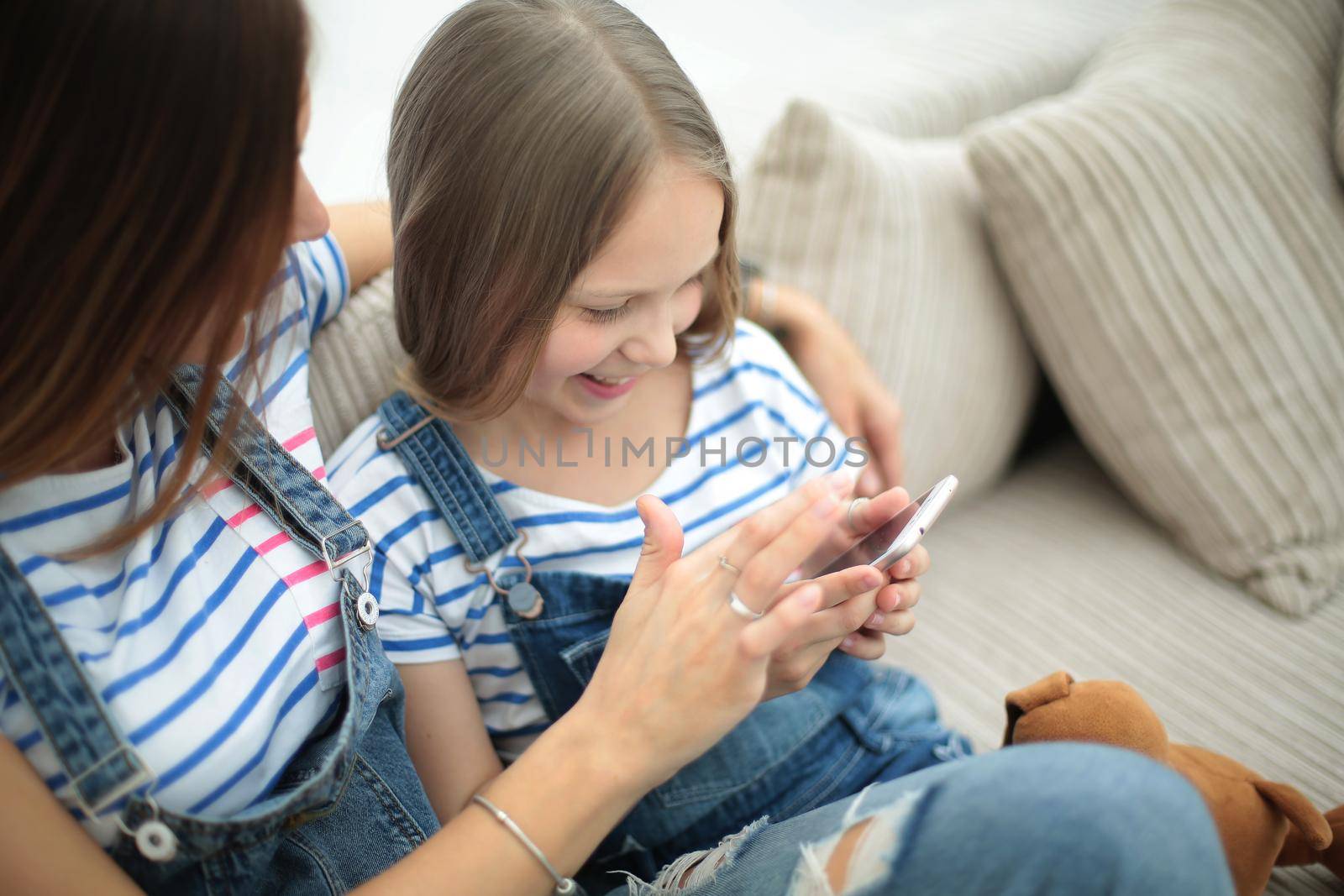mother and daughter talking, sitting on the couch .people and technology