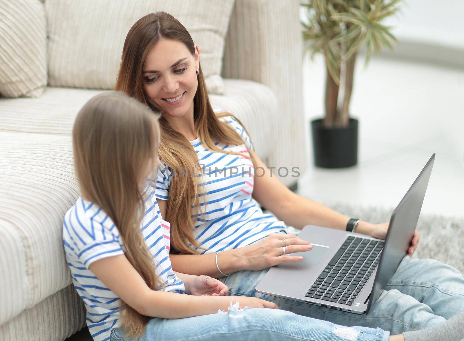 mother and daughter are watching their favorite TV show. by asdf