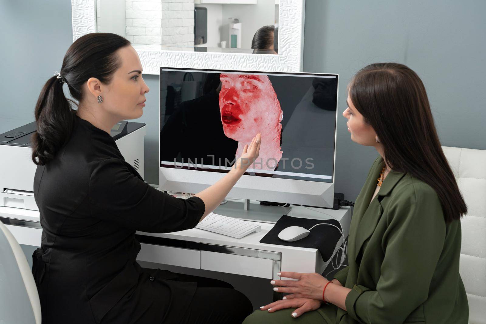 Cosmetologist showing female patient results of 3d camera shot of her face. Preperation for cosmetology procedure concept