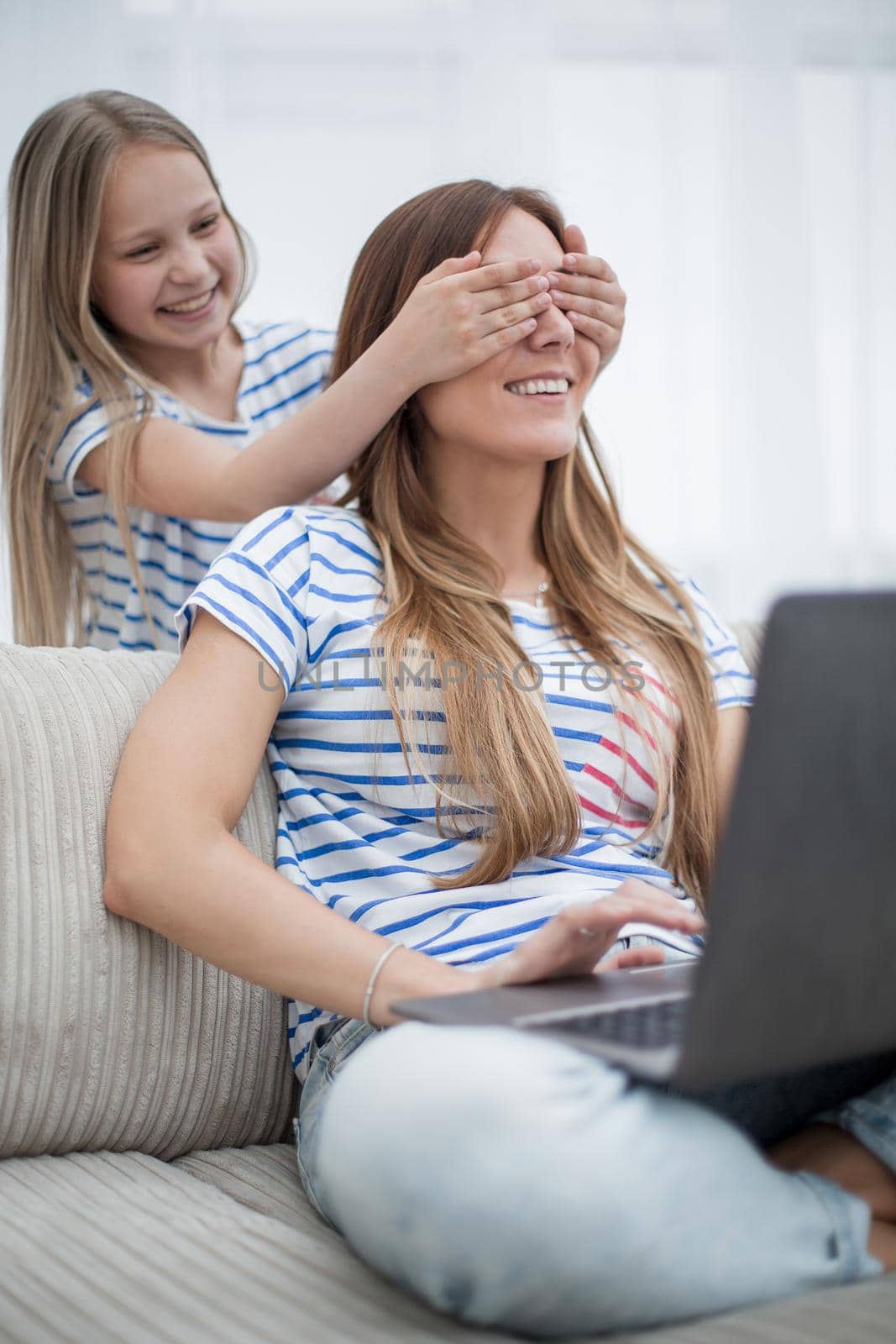 guess who. little girl closing her eyes to her mom . the concept of family happiness