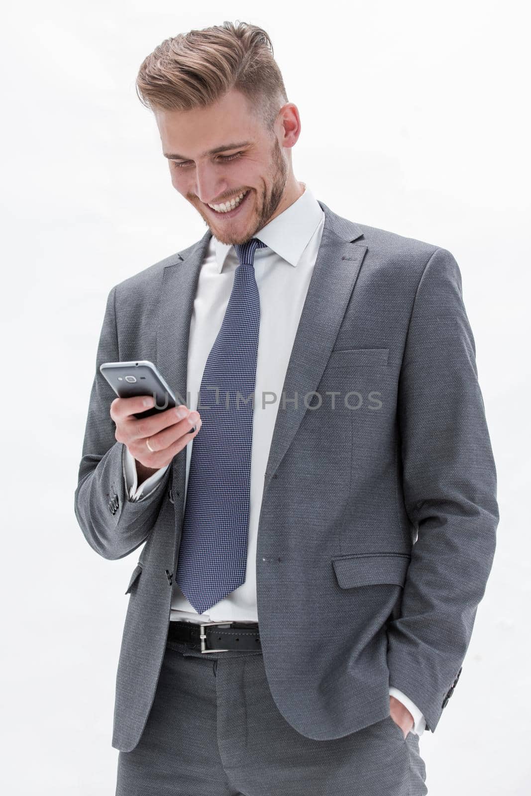 close up.smiling businessman reading text message on smartphone.isolated on white