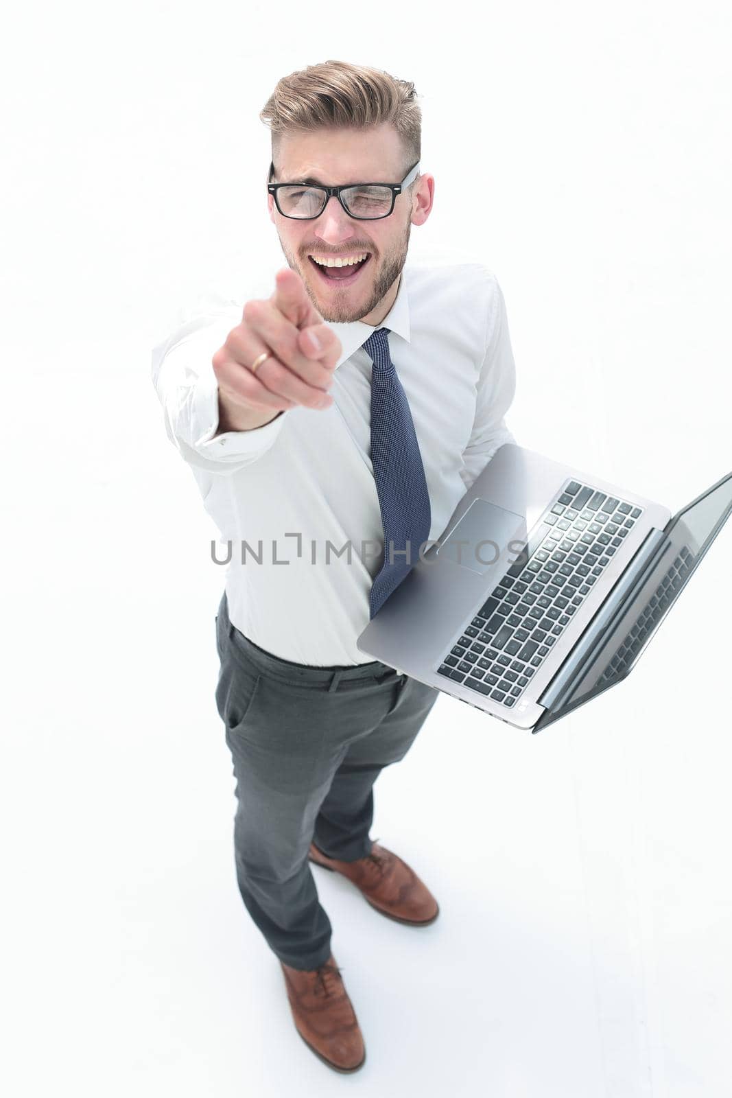 top view.smiling businessman with laptop pointing at you. the concept of choice