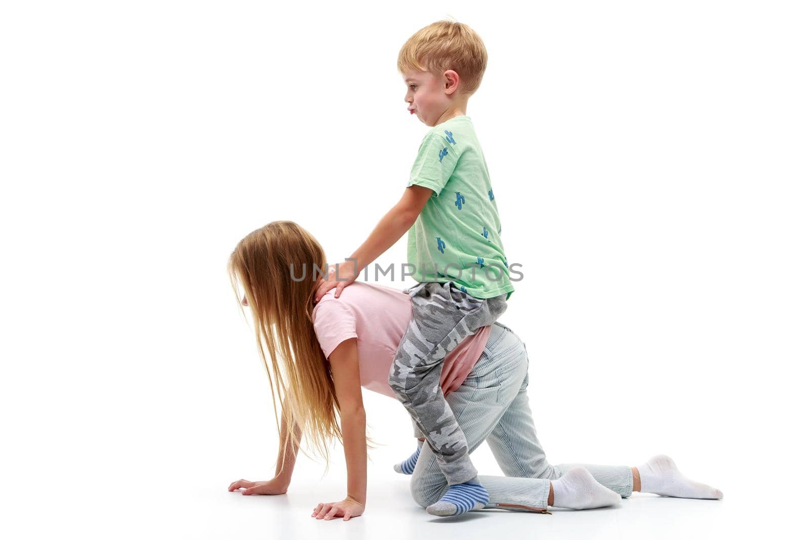 A little boy rides a girl like a horse. The concept of children's games. Isolated on white background.