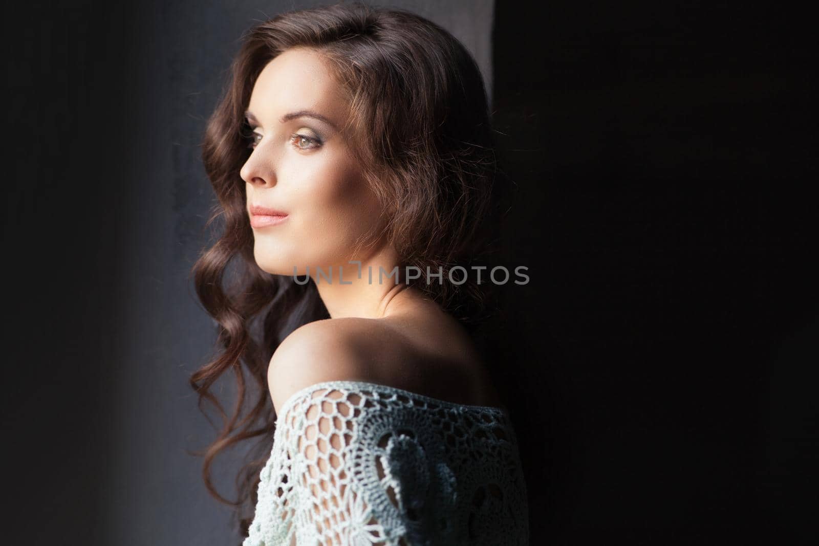 Young happy woman look out a window and smiling