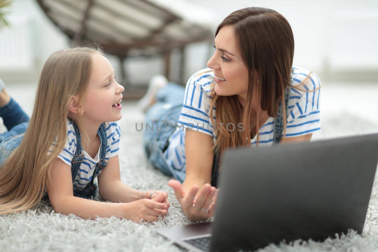 mom and little daughter discussing something while looking at the laptop by asdf