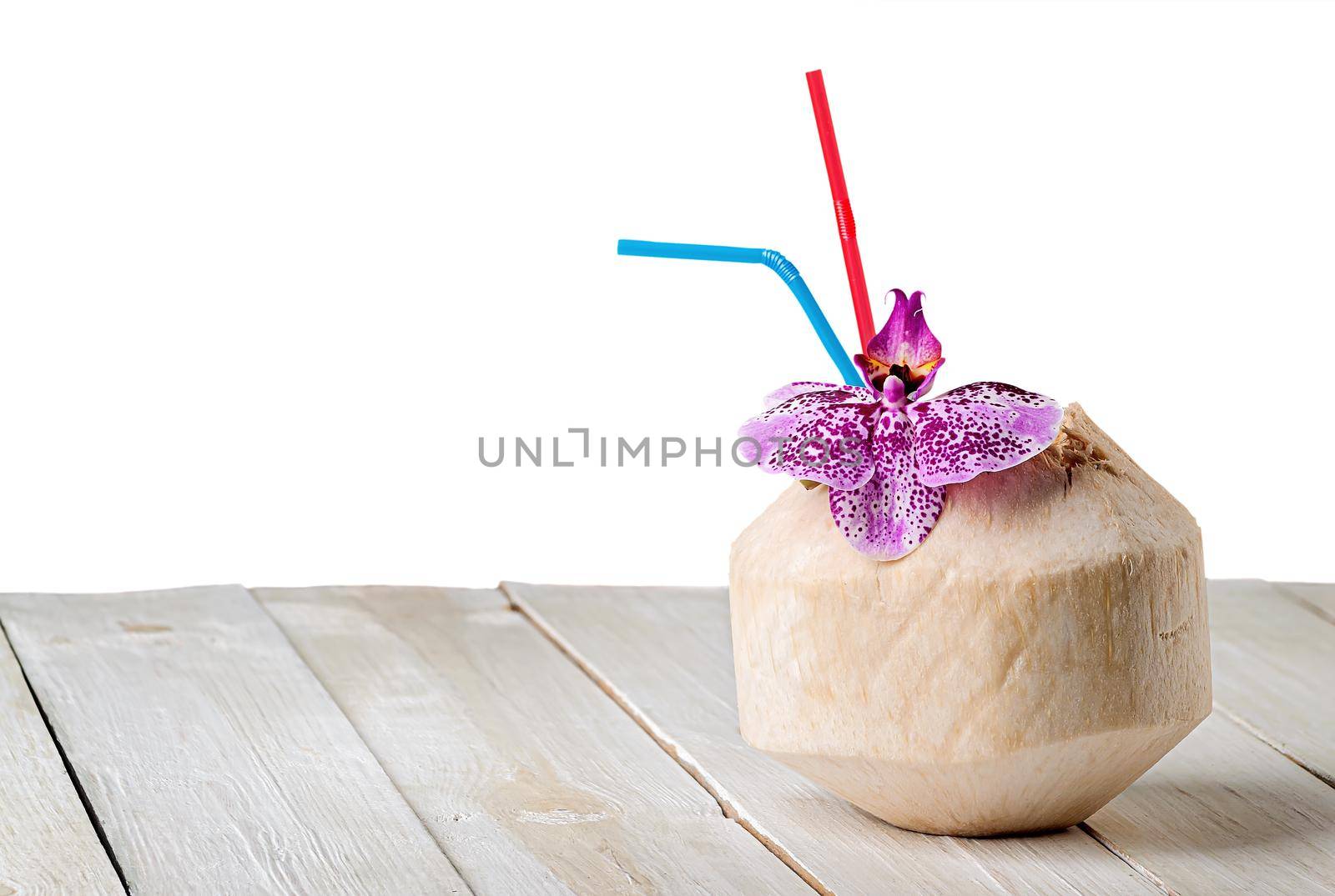 Young coconut with orchid flower on wooden table by Cipariss