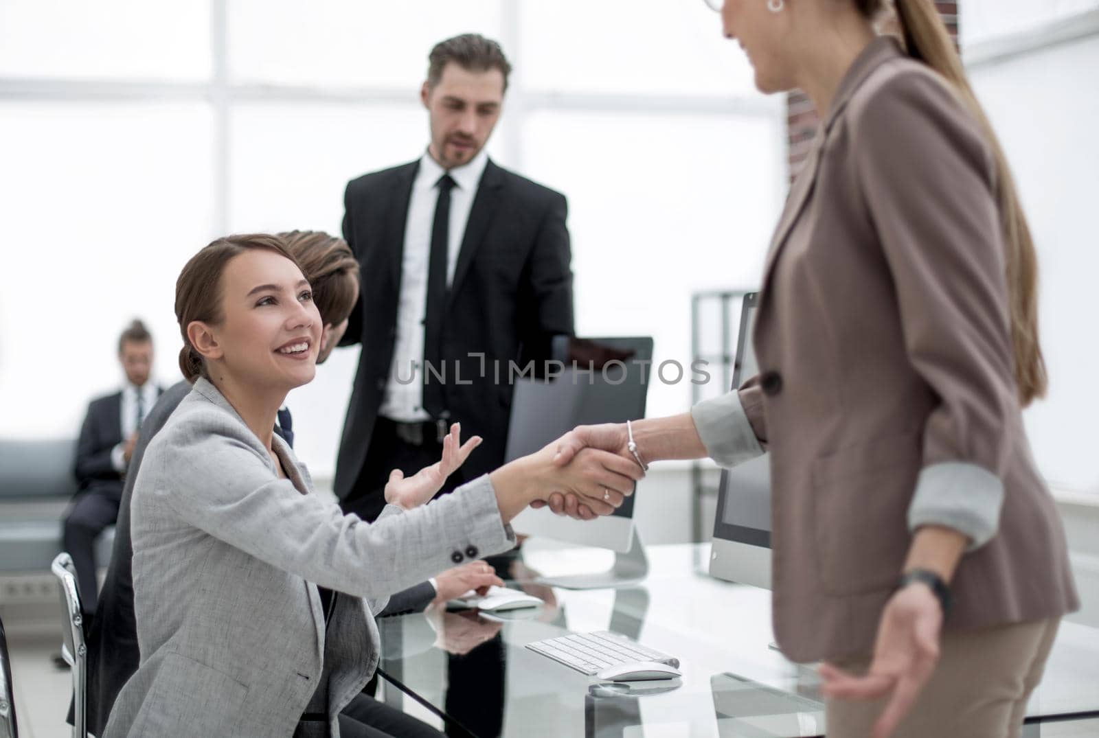 handshake two business women near the desktop by asdf