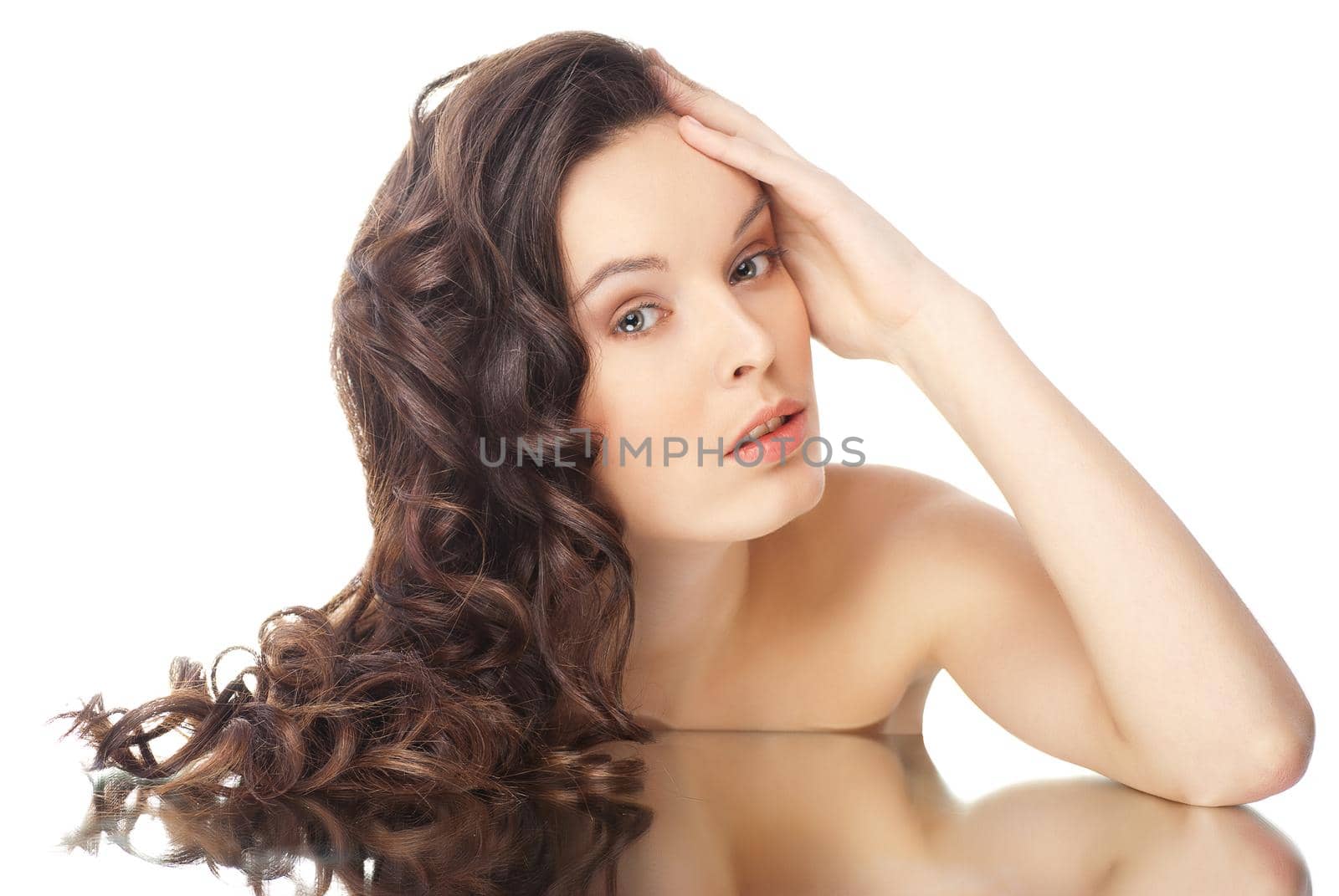 Beautiful sensual brunette woman with long wavy hairs and reflection - isolated on white